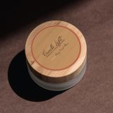 There is a candle label affixed to the top of the candle jar. The candle jar has a pleasant wooden lid, which looks nice with the custom label.